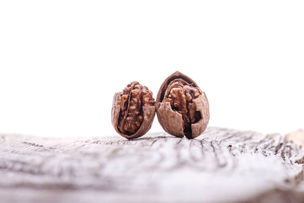 Cracked walnuts on natural wood background
