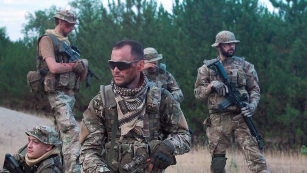 istock Men in camouflage with guns outside 812757062