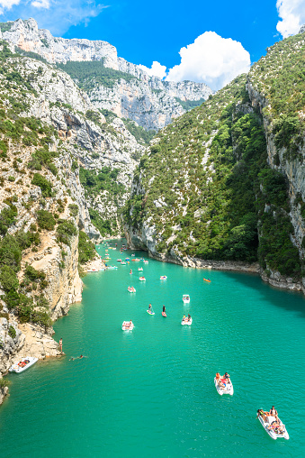 Verdon, France - June 27, 2017: Tourists enjoying a warm summer day in the Gorges du Verdon; renting boats to explore the gorges or feeling adventurous and even going for a swim.'