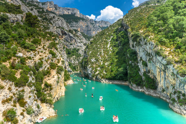 Verdon, France - June 27, 2017: Tourists enjoying a warm summer day in the Gorges du Verdon; renting boats to explore the gorges or feeling adventurous and even going for a swim.'