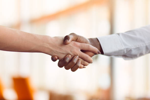 istock People at work: man and woman hand shaking at a meeting 812779224