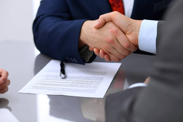 istock Two business man shaking hands to each other above signed contract 812781882