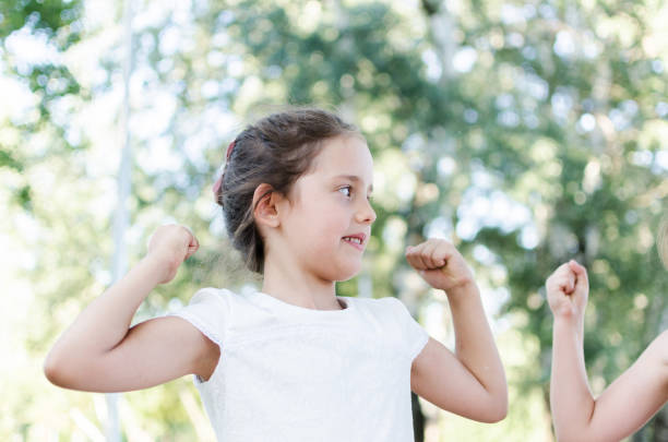 istock little girl showing her muscles 812784938