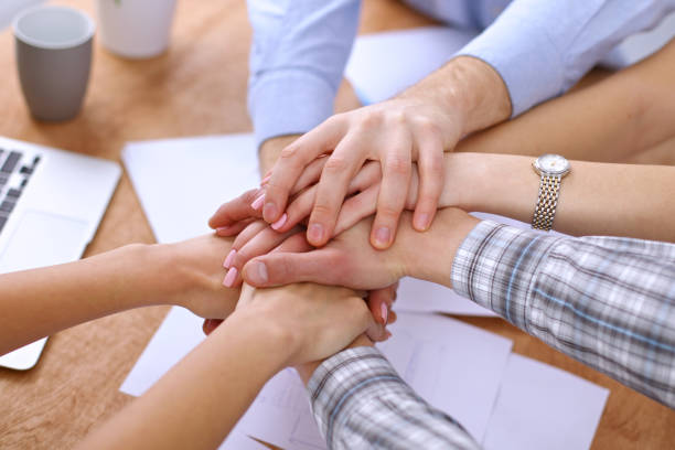 istock Business people joining hands over table 812785572