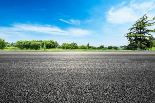 istock asphalt road and green tree in countryside 812798256