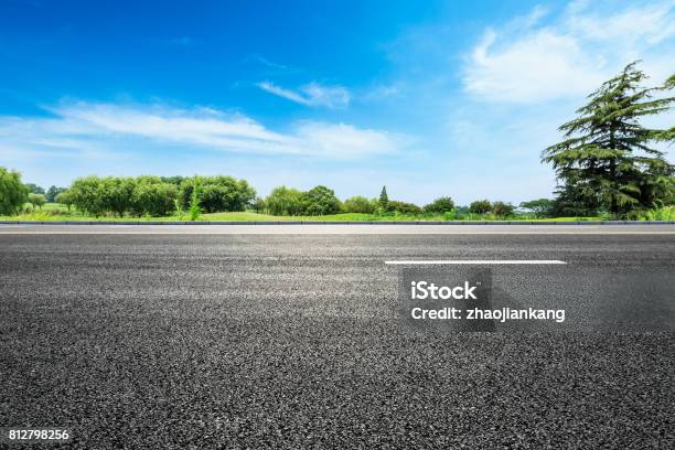 Asphalt Road And Green Tree In Countryside Stock Photo - Download Image Now - Sunny, Backgrounds, Road