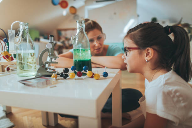 istock Girl and her mother doing scientific experiment 812807674