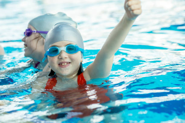 istock happy children kids group at swimming pool class learning to swim 812815332