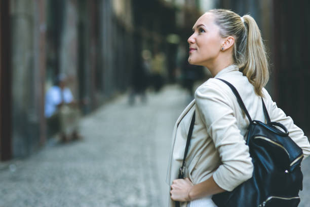 istock Young woman with backpack walking on the european streets 812820804