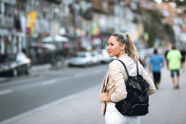 istock Young woman with backpack walking on the european streets 812820886