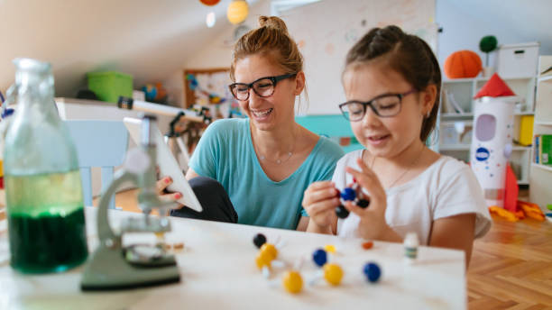 istock Schoolgirl and her teacher doing preparation for experiment 812836812