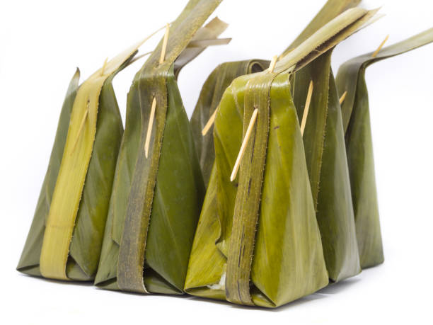 istock Thai Traditional Dessert (The banana leaf wrapped with coconut steamed flour),Kanom Sai Sai on white background 812842878