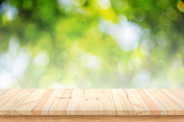 istock Wooden table on green bokeh background. 812845132