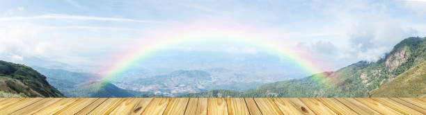 empty wooden table top and blurred view of rainbow at lanscape m - lpn imagens e fotografias de stock