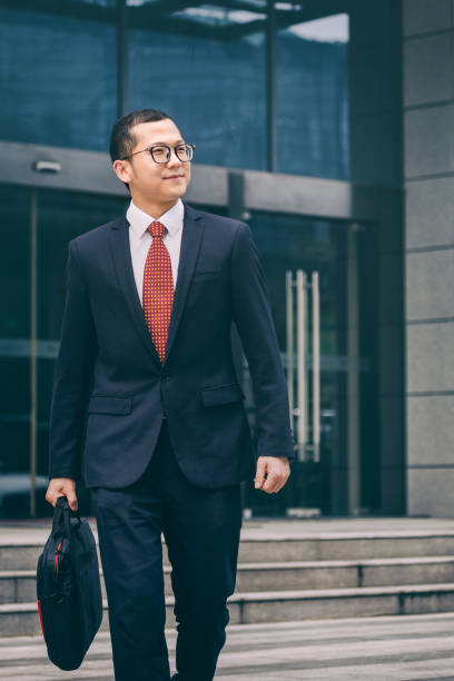 istock young businessman walking outside office 812864356