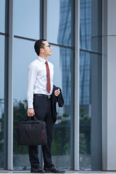 istock young businessman walking outside office 812871636