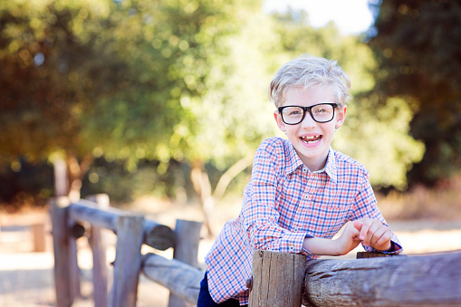 cute school boy student in glasses enjoying time outdoor, back to school concept