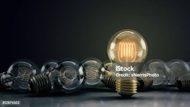 Multiple 3d Illustrated Incandescent Light Bulbs On A Reflective Surface Stock Photo - Download Image Now