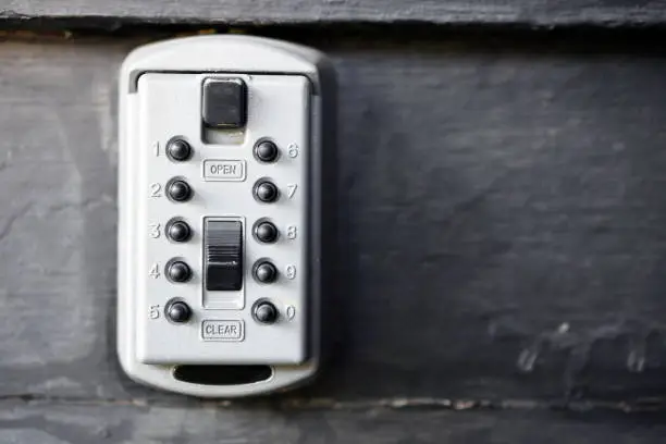 A close up image of an exterior lock box designed to hid a spare key.