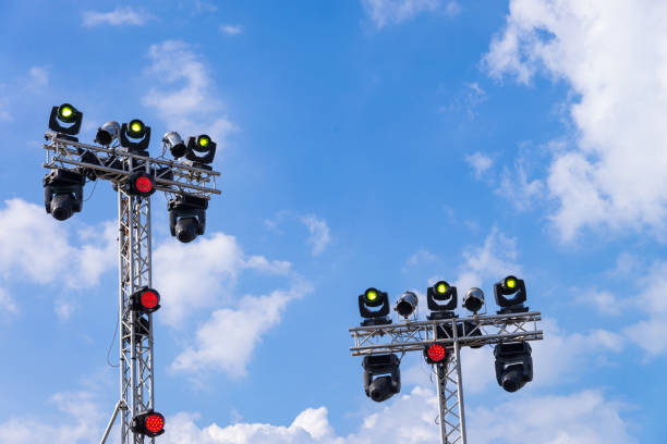 istock Illuminated multi-colored lights LED lights equipment attached to constuction steel frame. on outdoor concert stage with blue sky background 812874798