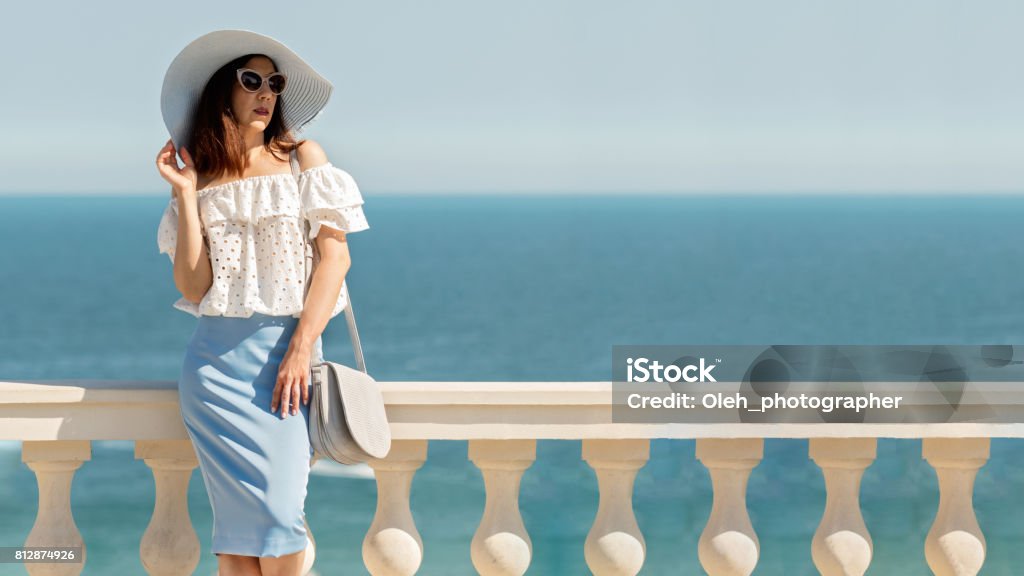 Junge Frau in einem weißen Bluse blau Bleistiftrock und Hut auf einem Hintergrund von den Meereshorizont. - Lizenzfrei Bleistiftrock Stock-Foto