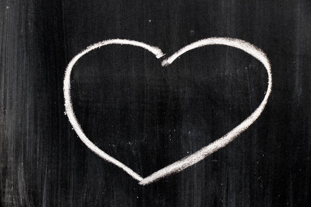 istock Chalk hand drawing as heart shape on black board background 812875016