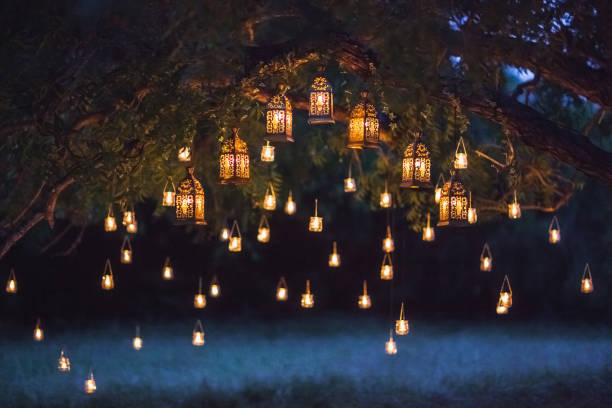 cérémonie de mariage de nuit avec beaucoup de lampes vintage et des bougies sur le grand arbre - ambiance événement photos et images de collection