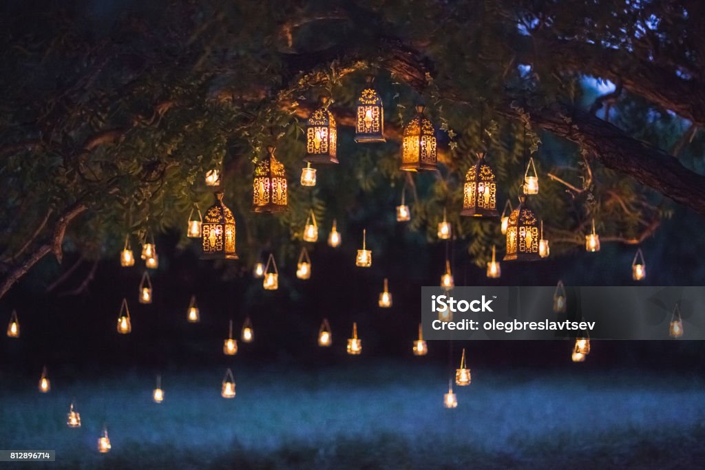 Night wedding ceremony with a lot of vintage lamps and candles on big tree Lighting Equipment Stock Photo