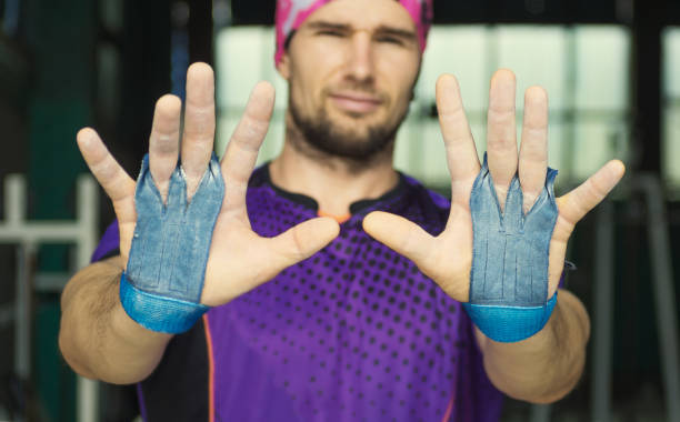 young muscular hipster sportsman shows palm protection grips stock photo