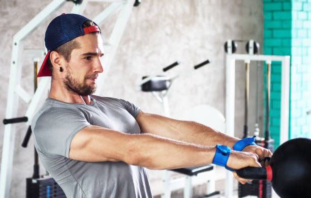 istock young muscular athlete lifting kettlebell weight in gym 812936500