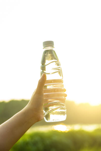 istock Hand holding a bottle of water in park 812936520