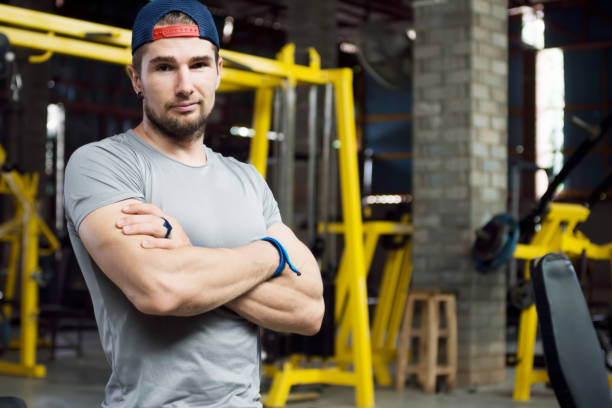istock Young muscular trainer standing arm cross looking in camera 812936538