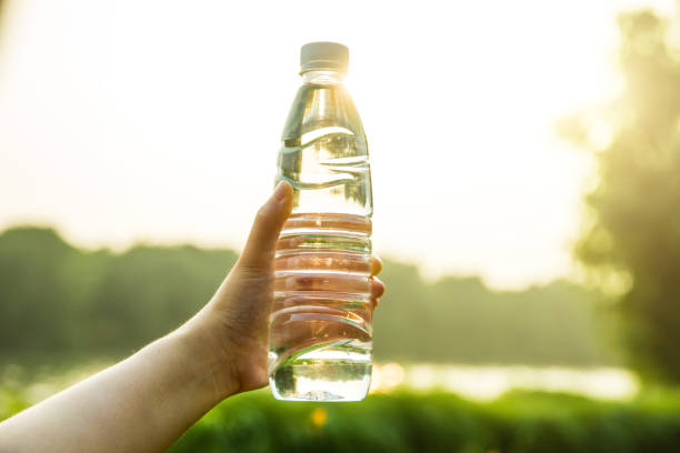 istock Hand holding a bottle of water in park 812936558
