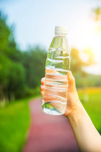 istock Hand holding a bottle of water in park 812936570