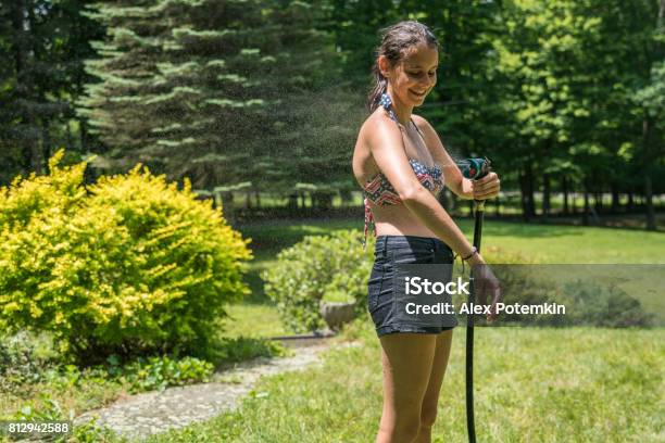 Luchten Zielig verdamping The 15yearsold Teenager Girl Wearing Swimsuit Take A Shower From The Garden  Rubber Hose On The Green Lawn At The Backyard Stock Photo - Download Image  Now - iStock