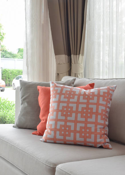 istock Graphic pattern, orange and gray pillow on beige sofa 812942834