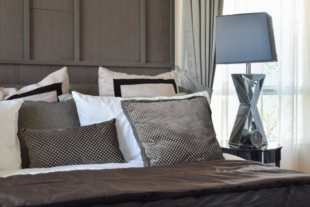 istock stylish bedroom interior design with black patterned pillows on bed and decorative table lamp. 812942866