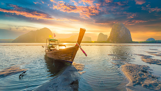 Hermosa puesta de sol en el mar tropical con larga cola en bote en el sur de Tailandia photo