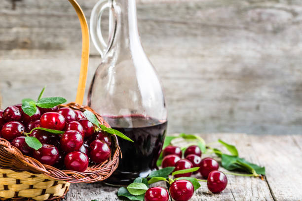 licor kirsch em frasco de vidro na mesa de madeira. álcool doce feito de frutas cereja - juice carafe glass decanter - fotografias e filmes do acervo