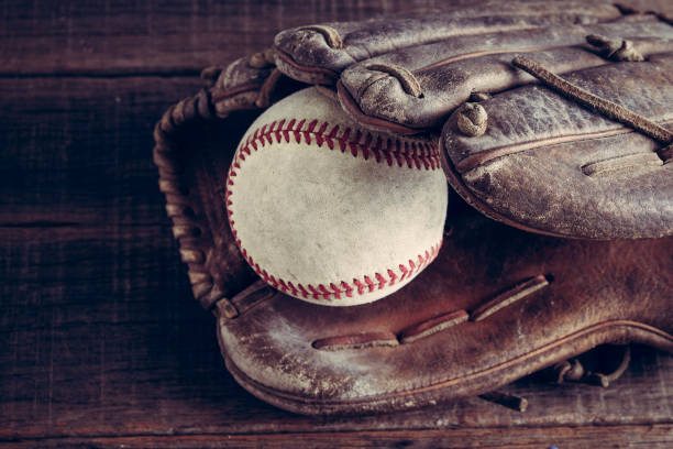 istock old Baseball and glove on wood background with filter effect retro vintage style 812957944