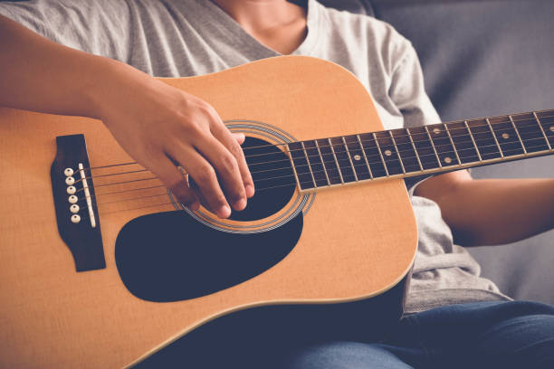 istock woman's hands playing acoustic guitar with filter effect retro vintage style 812958338