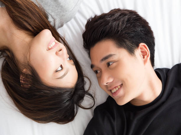 istock Young Asian Couple lay down on the bead 812964408