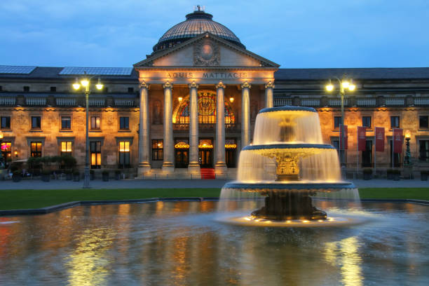 Kurhaus and Bowling Green in the evening with lights, Wiesbaden, WIESBADEN, GERMANY-MAY 24: Kurhaus and Bowling Green in the evening with lights on May 24, 2017 in Wiesbaden, Hesse, Germany. Wiesbaden is one of the oldest spa towns in Europe kurhaus casino stock pictures, royalty-free photos & images