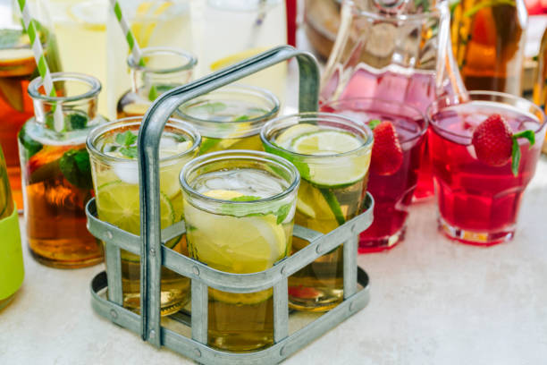 High angle view an Asian woman's hands placing empty glass jars into a wooden box, ready for recycling, showcasing a sustainable lifestyle.