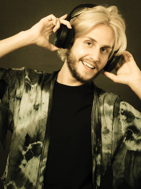 istock Blonde man singing in studio wearing headphones 812976800