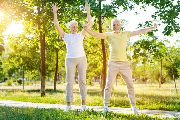 istock Overjoed aged couple doing sport exercises in the park 812977336