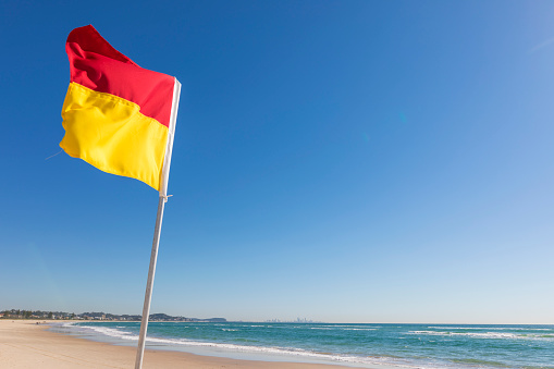 Gold Coast, Australia - July 5, 2017: Surf Lifesaving flag on the beach at Kirra near Coolangatta on the Gold Coast in Australia