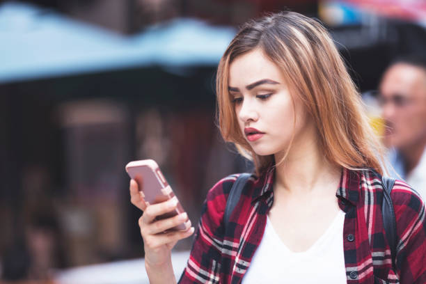 istock Attractive tourist using her phone while roaming the streets of Shinsekai 812984288