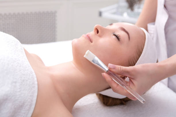 istock Woman gets face mask by beautician at spa 812993252