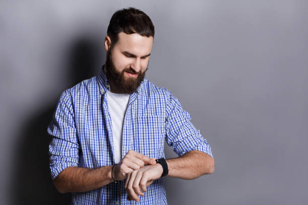 istock Bearded man clicking on screen of his smart watch 812994670